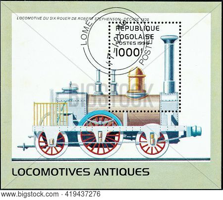 Togo - Circa 1996: A Stamp Printed In Togo Shows An Old Robert Stephenson Six-wheel Locomotive From 