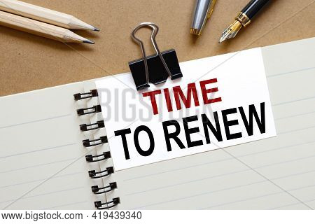 Time To Renew . The Inscription On The Business Card Is Attached To The Notebook.