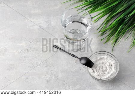 A Glass Of Water, Collagen Powder On A Light Background. Healthy Lifestyle Concept. Hydrolyzed Colla