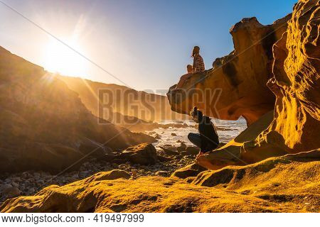 A Young Woman Looking At The Sea At Sunset In The Cove Of Stones On The Mountain Of Jaizkibel In The