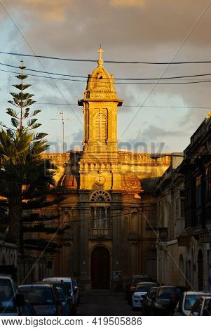 Typical Maltese Church In Sunset Hidden Between Small Historical Streets In Hal Balsan