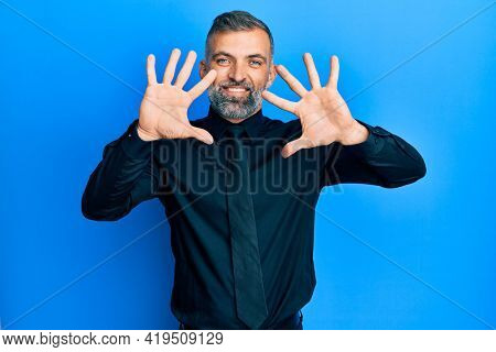 Middle age handsome man wearing business shirt and tie showing and pointing up with fingers number ten while smiling confident and happy. 