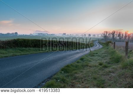Sunrise In Ireland, Country Site Landscape Photography With Blue Sky And Fog Over The Horizone.