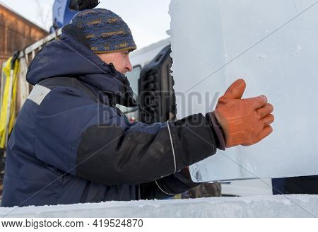 Slinger In A Blue Jacket Unloading Ice Blocks
