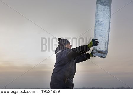 Slinger In A Blue Jacket Unloading Ice Blocks