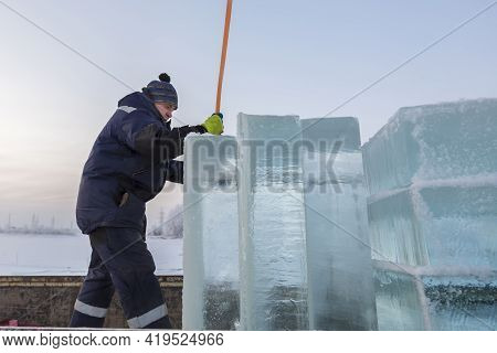 Slinger In A Blue Jacket Unloading Ice Blocks