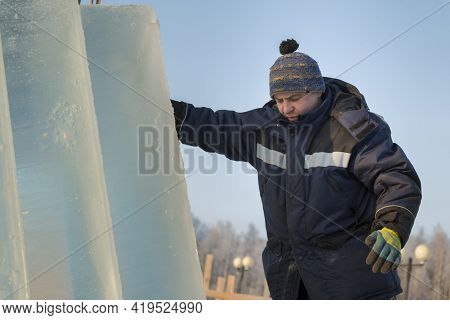 Slinger In A Blue Jacket Unloading Ice Blocks