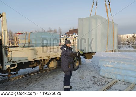 Slinger In A Blue Jacket Unloading Ice Blocks