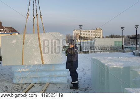 Slinger In A Blue Jacket Unloading Ice Blocks