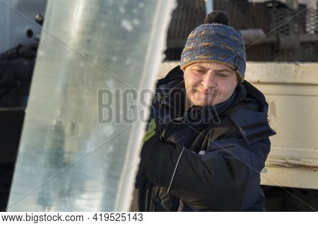 Slinger In A Blue Jacket Unloading Ice Blocks