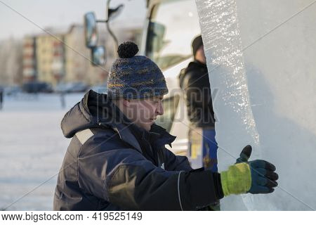 Slinger In A Blue Jacket Unloading Ice Blocks
