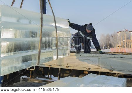 Slinger In A Blue Jacket Unloading Ice Blocks