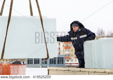 Slinger In A Blue Jacket Unloading Ice Blocks