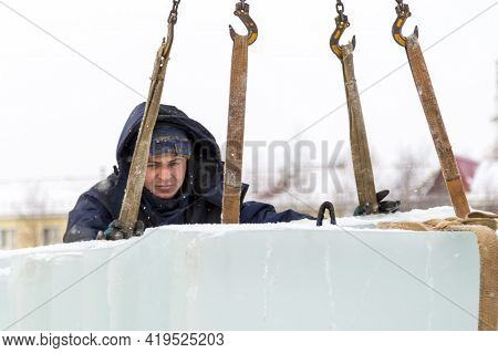 Slinger In A Blue Jacket Unloading Ice Blocks