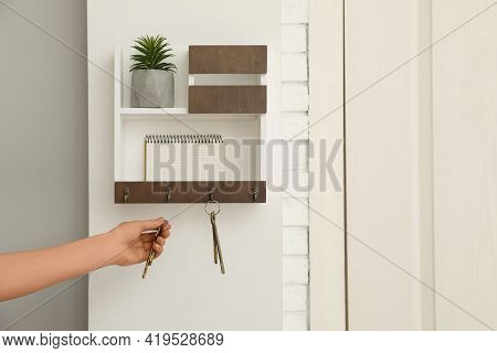 Woman Taking Keys From Hanger In Hallway, Closeup