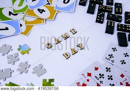 Kiev, Ukraine - 10.03.2021 Text Game Day. Dominoes Puzzles Playing Cards Around. The Concept Of Rela