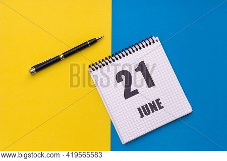 June 21th. Day 21 Of Month, Calendar Date. Notebook With A Spiral And Pen Lies On A Yellow-blue Back