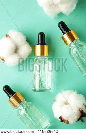 Serum Or Oil Bottle With Pipette And Cotton Twig On Mint Background. Beauty Product, Skin Care Conce