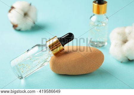Serum Or Oil Bottle With Pipette And Cotton Twig On Blue Background. Beauty Product, Skin Care Conce