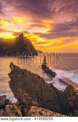 Long Exposure In The Orange Sunset At The Lighthouse In The Municipality Of Pasajes San Juan In Gipu