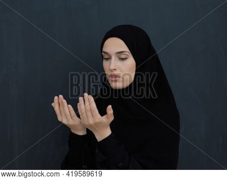Portrait of young Muslim woman making dua