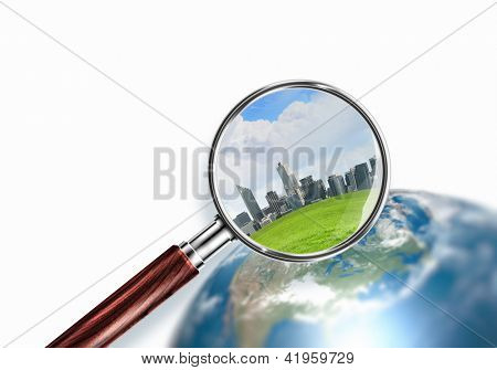 Planeta mini conceptual con rascacielos en él con una lupa. Elementos de esta imagen son f