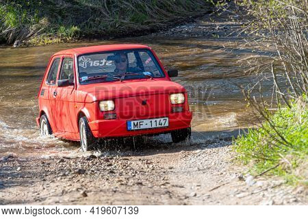 Madona, Latvia - May 01, 2021: Red Oldtimer Car Fiat 126 Overcomes Water Obstacle