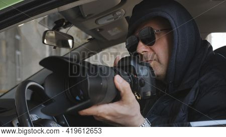 The Concept Spy Or Private Detective Takes Photos With A Long-focus Lens From The Car Window.