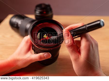 Photographer Hands Close Up Cleaning Camera Lens With Black Professional Brush, Closeup, Removing Du