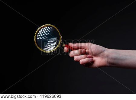 Magnifier Or Loupe In Woman Hand On Black Background. Concept Of Searching And Studying