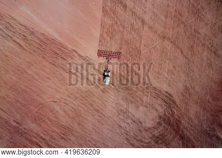 Aerial View Of A Tractor Plowing A Field. Copy Space.