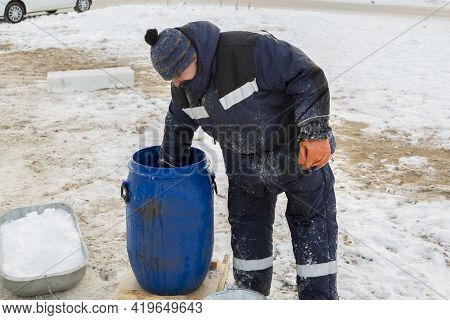 Worker Pours Water From A Barrel Into A Bucket