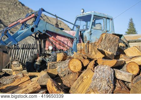 A Pile Of Sawn Wood, Chocks, Lies In The Yard On The Street In The Village Against The Background Of