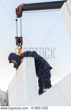 A Portrait Of A Fitter In A Blue Jacket At The Hook Of A Truck Crane