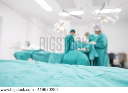 Blurred Image Background Of Medical Team Performing Surgical Operation In Operating Room. An Operati