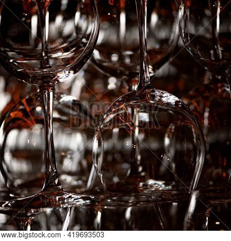 Clean Wine Glasses Dry On Bar Counter Acklit On Black Background. Abstract Background. Square Format