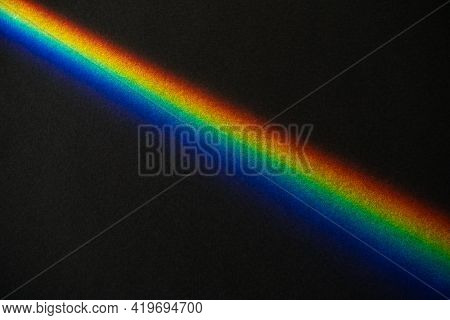 Rainbow Prism Streek On Black Textured Paper Background