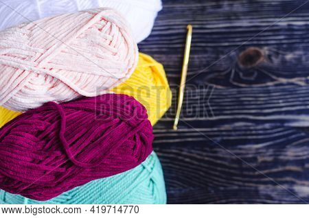 Skeins Of Colored Yarn On A Dark Wooden Background, Kopi Space. Needlework Against The Background Of