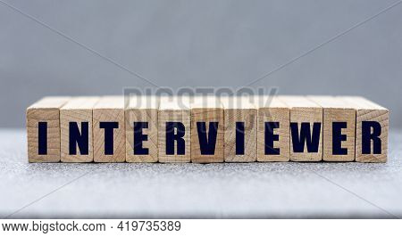 Interviewer - Word On Wooden Bars On A Gray Background. Business Concept