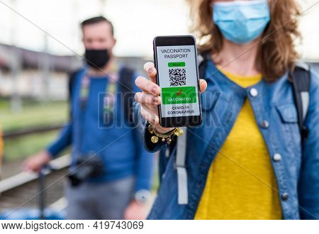 health Vaccine Passport for Coronavirus or Covid-19. Traveller Using Mobile Phone with Vaccination in Immune Status to Certificated International Traveling in train station