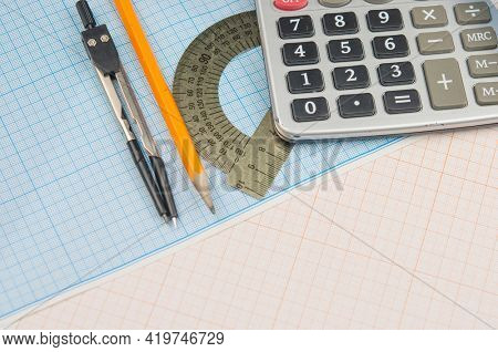 Mathematical instruments lie on a graph paper with copy space for text. Math graphic tools concept.
