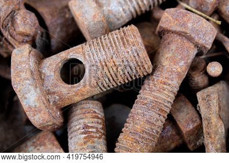 Old Rusty Bolts And Nuts. Fasteners On The Trash Can. The Iron Bolts Are Rusty. Corrosion Of Metal O