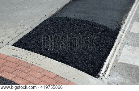 An Asphalt Repair Worker With Hot Black Material Aligns The Holes After The Excavation Work At The P