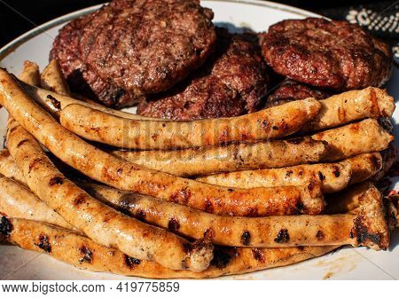 Roasted Bbq Sausages With Grillmarks And Grilled Homemade Meat Bbq Burgers For Hamburger On Plate. O