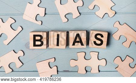 Blank Puzzles And Wooden Cubes With The Text Bias Lie On A Light Blue Background.