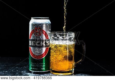 Can Of Beck`s Or Becks Beer And Beer Glass On Dark Background. Illustrative Editorial Photo Shot In