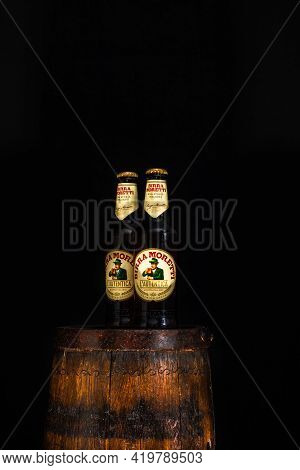 Bottle Of Birra Moretti Beer On Wooden Barrel With Dark Background. Illustrative Editorial Photo Buc