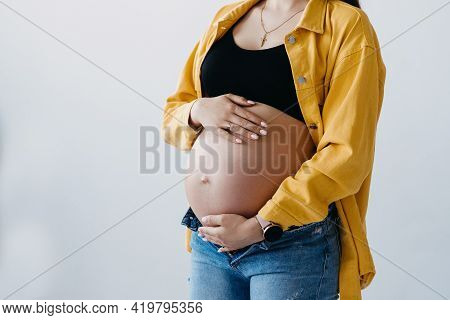 Cute Pregnant Belly Isolated On White. Side View Of A Young Pregnant Woman Hugging Her Naked Belly W
