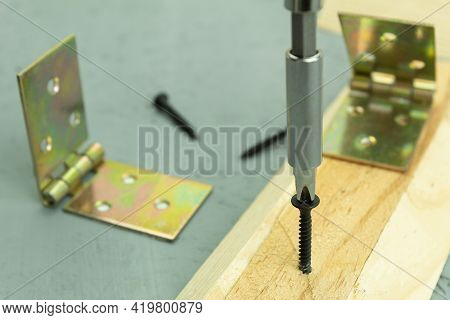The Self-tapping Screw Is Screwed Into The Board. Screwing A Self-tapping Screw Into A Wooden Board 
