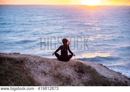 Woman Meditating And Doing Youga At Sunset